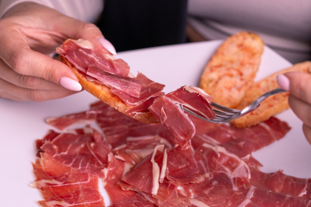 Slices of jamón served on toast, highlighting its rich texture and flavor.